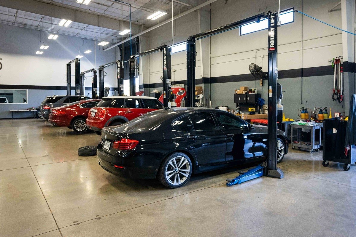 Total Auto Works service floor with multiple lifts and vehicles in Austin, Texas